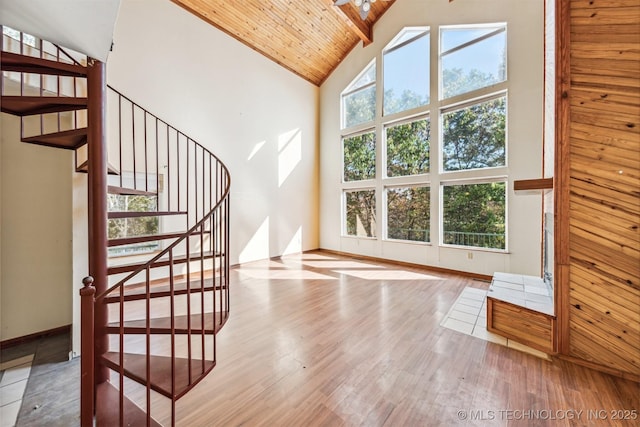 interior space with high vaulted ceiling, wood finished floors, wood ceiling, and baseboards