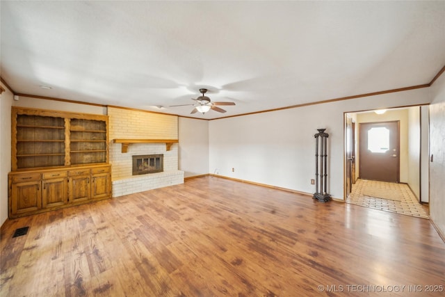 unfurnished living room with a fireplace, ornamental molding, and wood finished floors