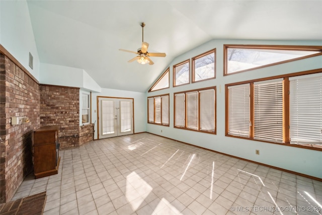 unfurnished living room featuring ceiling fan, high vaulted ceiling, brick wall, and tile patterned floors