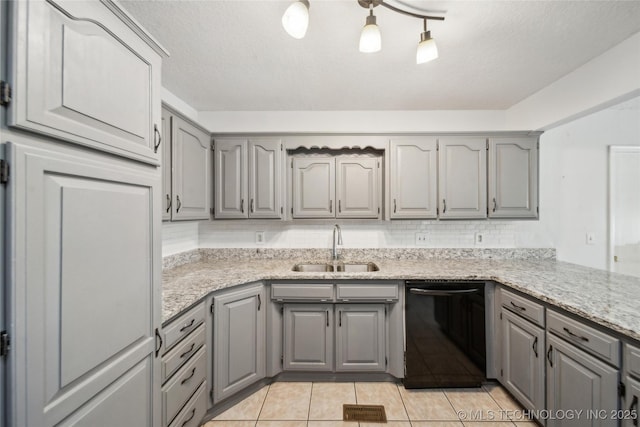 kitchen featuring visible vents, backsplash, gray cabinetry, a sink, and dishwasher