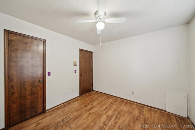 empty room with a ceiling fan and light wood-type flooring