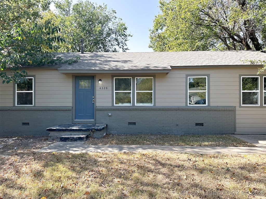 ranch-style house with crawl space, roof with shingles, and brick siding