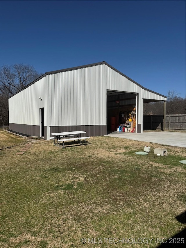 view of pole building featuring a lawn and fence