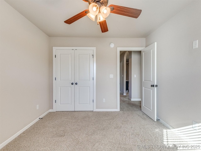 unfurnished bedroom featuring carpet floors, a ceiling fan, baseboards, and a closet