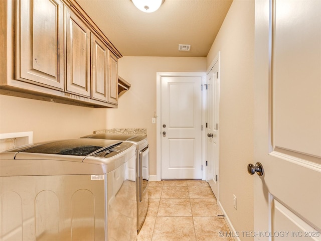 laundry room with cabinet space, light tile patterned floors, baseboards, visible vents, and independent washer and dryer