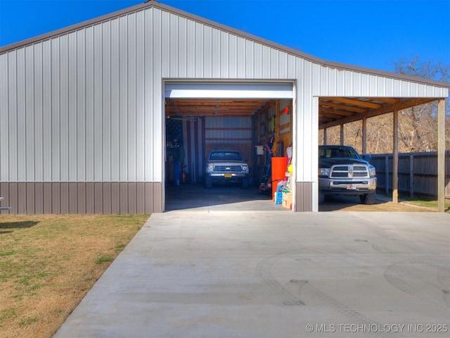 exterior space featuring a garage, concrete driveway, and fence