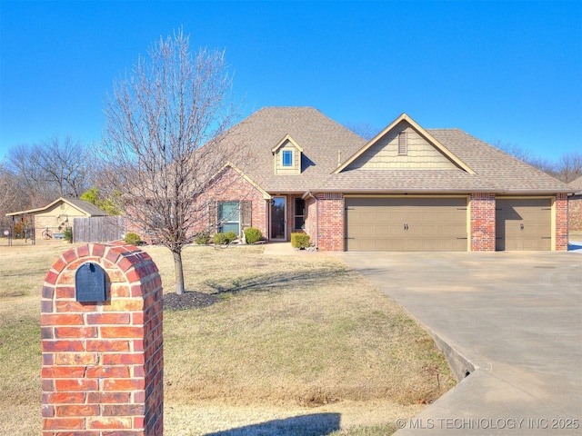 view of front of house featuring brick siding, a shingled roof, an attached garage, a front yard, and driveway