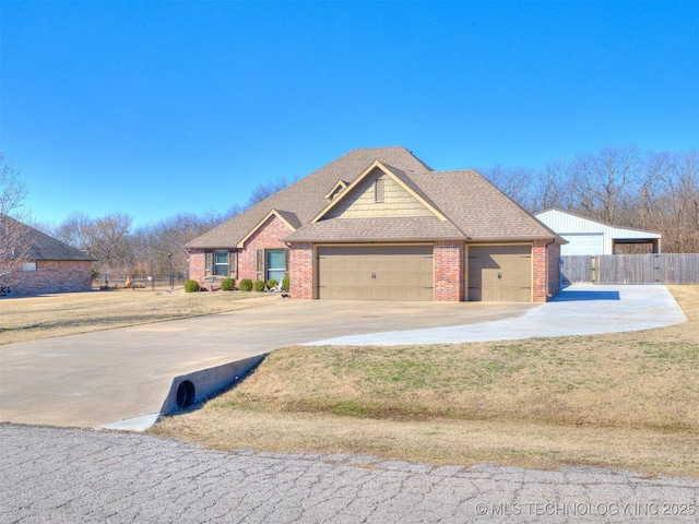 view of front of property featuring an attached garage, fence, brick siding, driveway, and roof with shingles