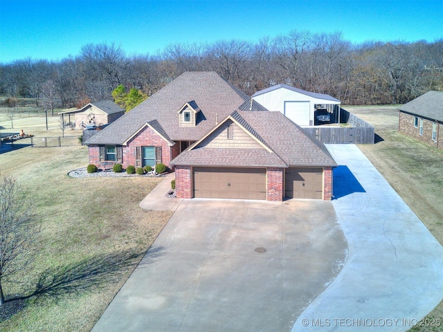 craftsman house featuring driveway, roof with shingles, fence, a front yard, and brick siding