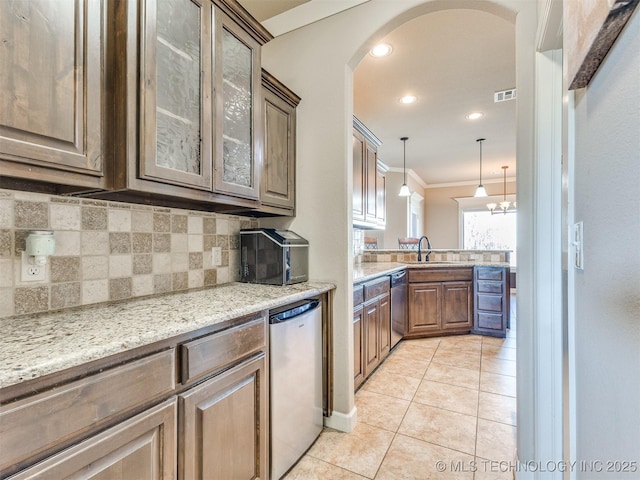 kitchen with arched walkways, a sink, stainless steel dishwasher, ornamental molding, and decorative backsplash