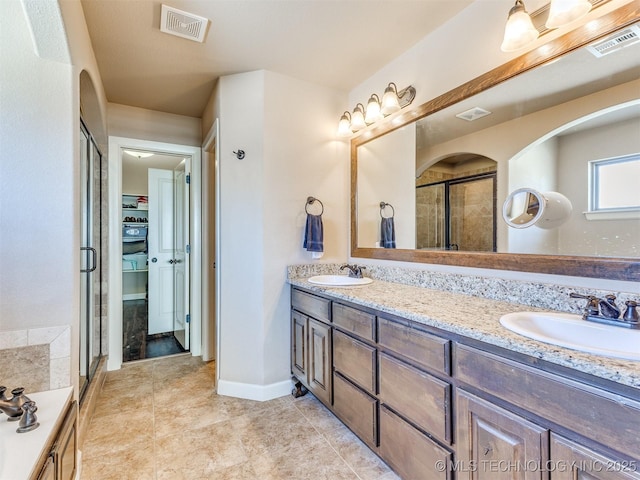 full bathroom featuring visible vents, a sink, a shower stall, and a spacious closet