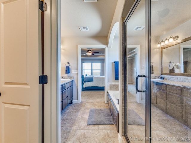 ensuite bathroom featuring a stall shower, ensuite bath, visible vents, and vanity