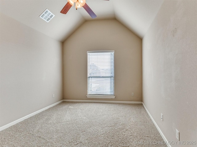 carpeted empty room with ceiling fan, lofted ceiling, visible vents, and baseboards