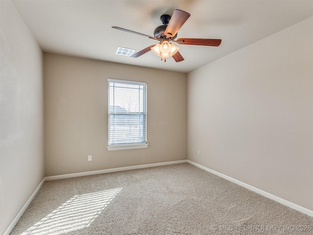 carpeted empty room featuring a ceiling fan, visible vents, and baseboards