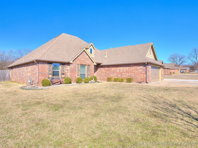 view of front of property with roof with shingles, brick siding, a front lawn, and an attached garage