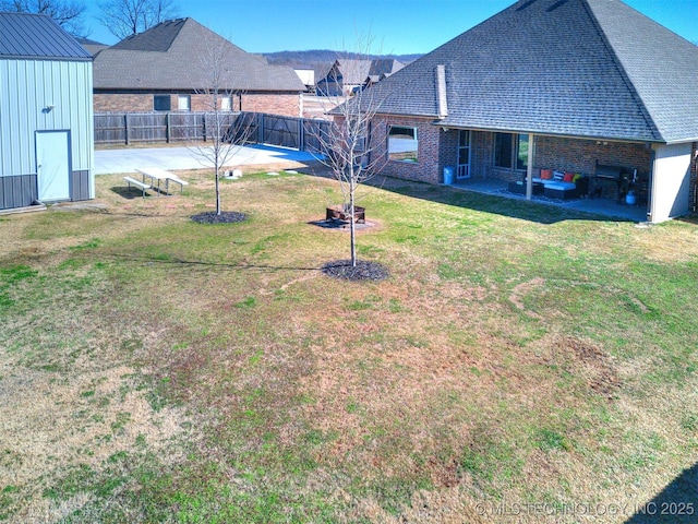 view of yard with an outbuilding, a patio, and a fenced backyard