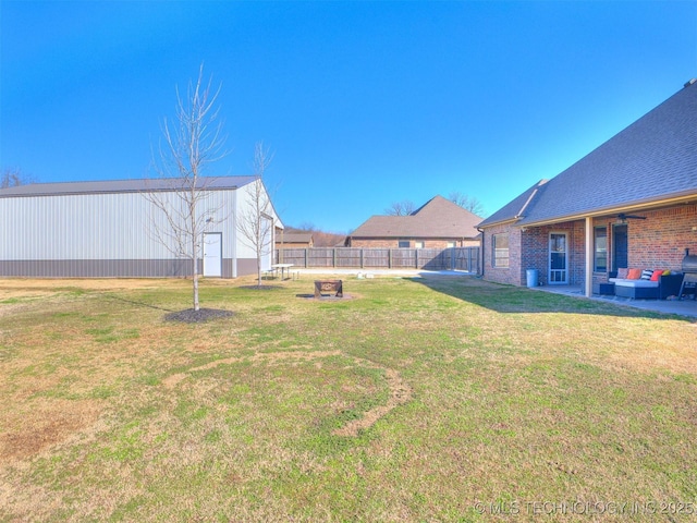 view of yard featuring an outbuilding, a fenced backyard, and an outdoor structure