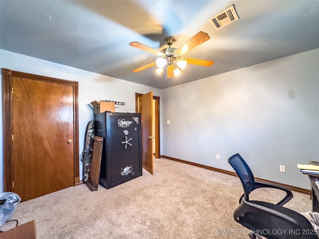 carpeted office with baseboards, visible vents, and a ceiling fan