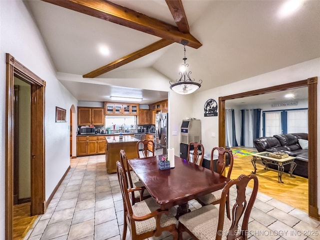 dining space with vaulted ceiling with beams, baseboards, and light tile patterned floors