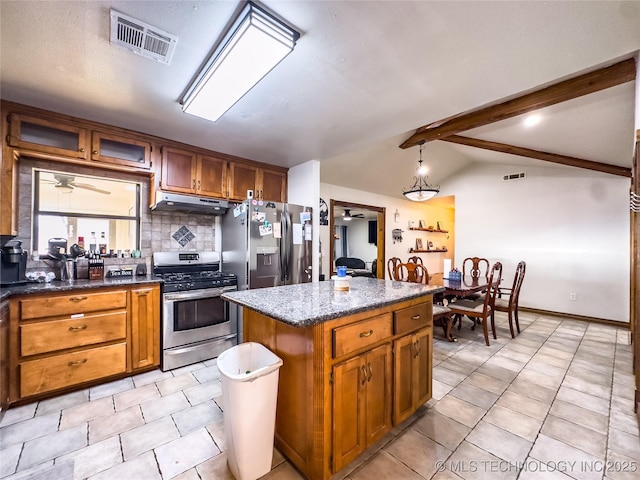 kitchen featuring brown cabinets, stainless steel appliances, visible vents, lofted ceiling with beams, and under cabinet range hood