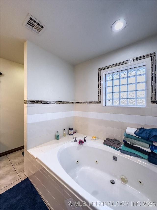 bathroom featuring tile patterned flooring, visible vents, and a jetted tub