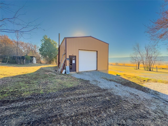 detached garage with gravel driveway