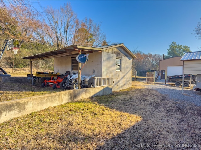 view of side of home with an outbuilding and concrete block siding