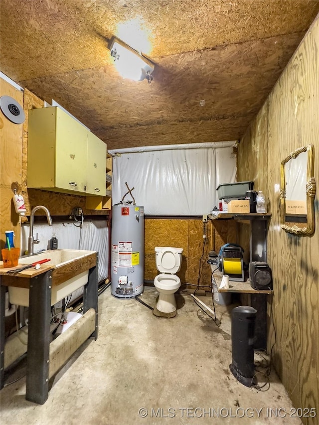 interior space with water heater, a workshop area, and unfinished concrete floors