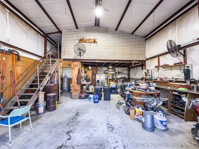 garage featuring water heater, a workshop area, and metal wall