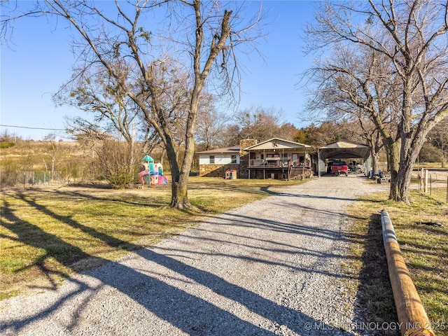 view of front facade with a front yard, playground community, and driveway