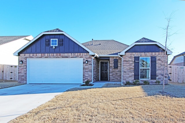 view of front of home featuring a shingled roof, concrete driveway, an attached garage, fence, and a front yard