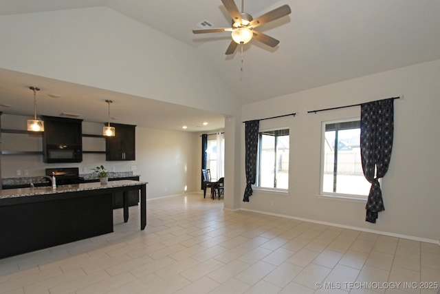 kitchen featuring black microwave, baseboards, light stone counters, high vaulted ceiling, and pendant lighting