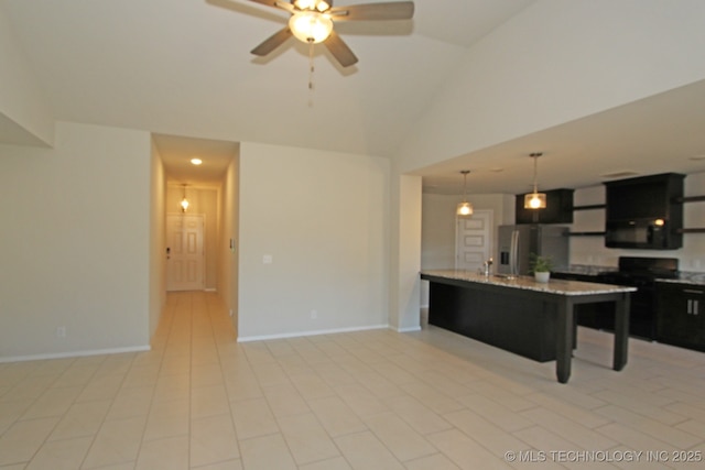 kitchen featuring decorative light fixtures, lofted ceiling, light stone countertops, dark cabinetry, and stainless steel fridge with ice dispenser