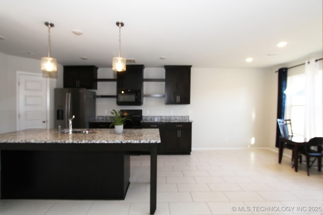 kitchen featuring black microwave, recessed lighting, stove, stainless steel fridge, and decorative light fixtures