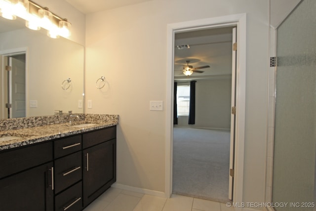 full bathroom with double vanity, a ceiling fan, a sink, tile patterned flooring, and baseboards