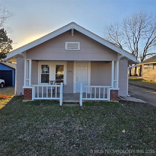 view of front of property with covered porch and a front yard