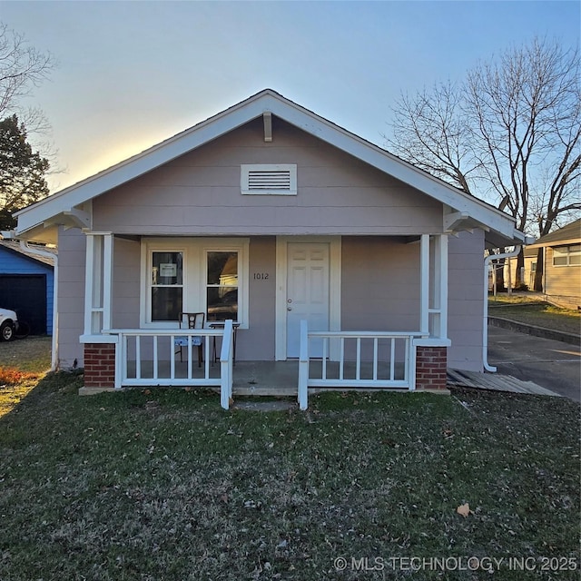 bungalow-style home with a front lawn and a porch