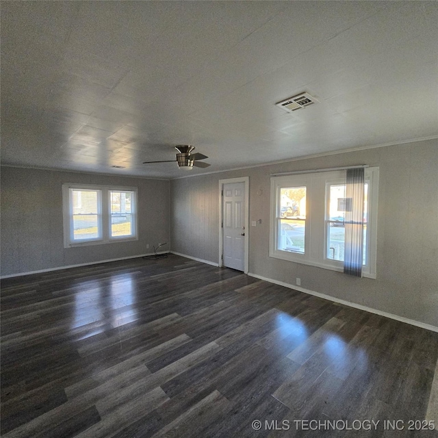 interior space featuring dark wood finished floors, visible vents, a ceiling fan, ornamental molding, and baseboards