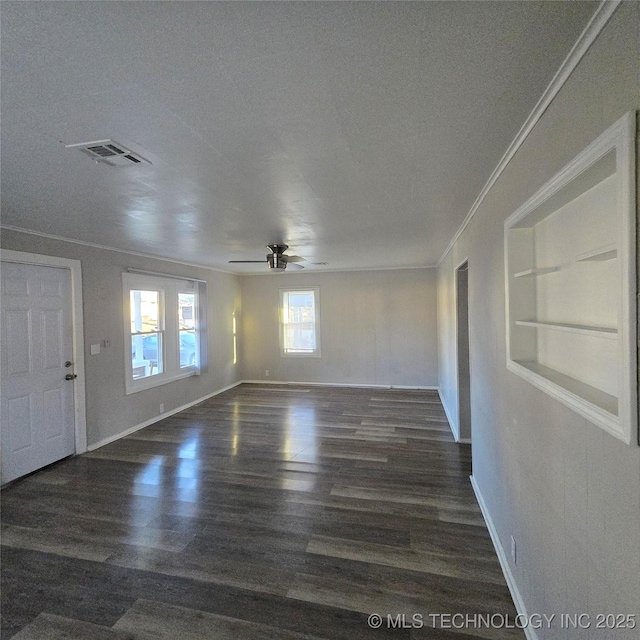 unfurnished room featuring ceiling fan, built in shelves, wood finished floors, visible vents, and crown molding