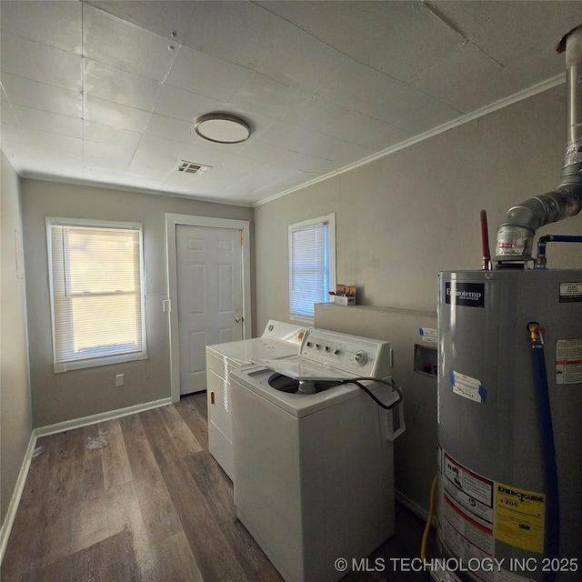 clothes washing area with laundry area, baseboards, washer and clothes dryer, wood finished floors, and water heater