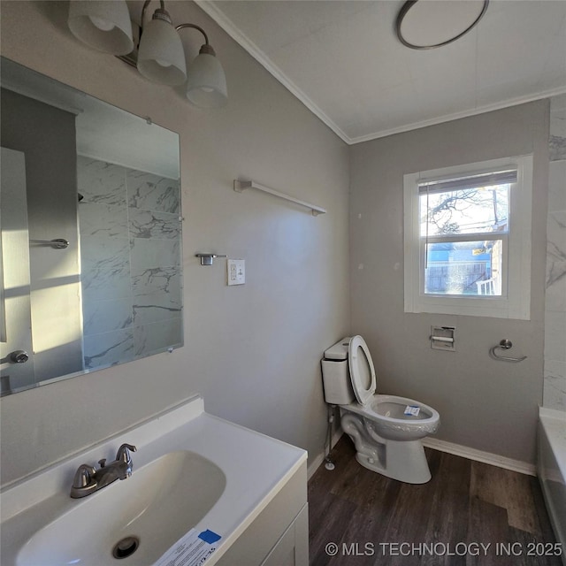 full bathroom featuring crown molding, toilet, vanity, wood finished floors, and a tub