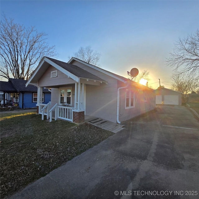 view of front of home featuring a garage, a porch, and an outdoor structure