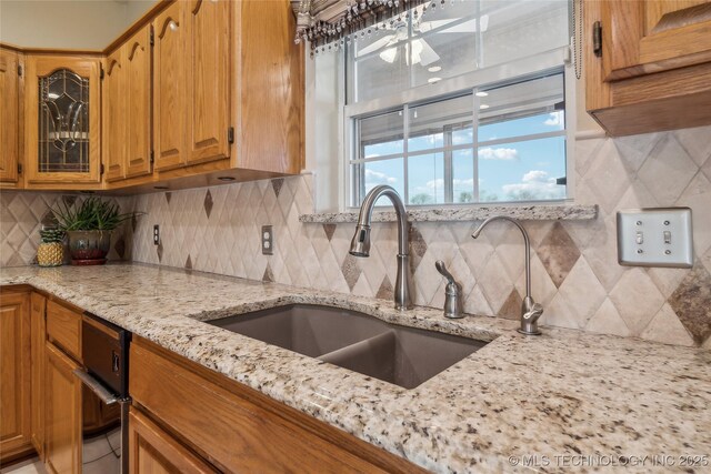 63320 E 293rd Rd, Grove, OK 74344 - kitchen with tasteful backsplash, glass insert cabinets, light stone countertops, and a sink