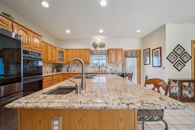 63320 E 293rd Rd, Grove, OK 74344 - kitchen featuring tasteful backsplash, fridge, dobule oven black, a sink, and a center island with sink