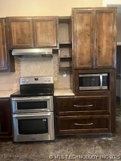 64 Crescent, Ardmore, OK 73401 - kitchen with stainless steel appliances, under cabinet range hood, dark brown cabinets, and light countertops
