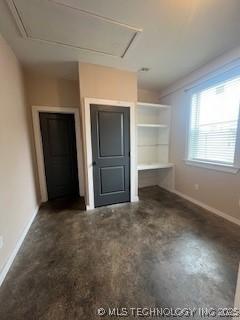 64 Crescent, Ardmore, OK 73401 - unfurnished living room with attic access and baseboards