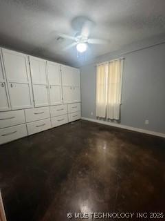 64 Crescent, Ardmore, OK 73401 - unfurnished bedroom featuring baseboards, a ceiling fan, and concrete flooring