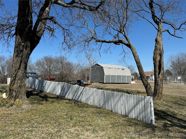 view of yard featuring a shed, an outdoor structure, and fence