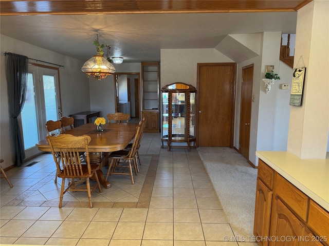 dining area featuring light colored carpet and light tile patterned flooring