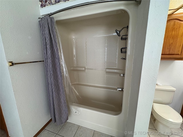 full bathroom featuring a textured wall, shower / bath combination with curtain, tile patterned flooring, and toilet